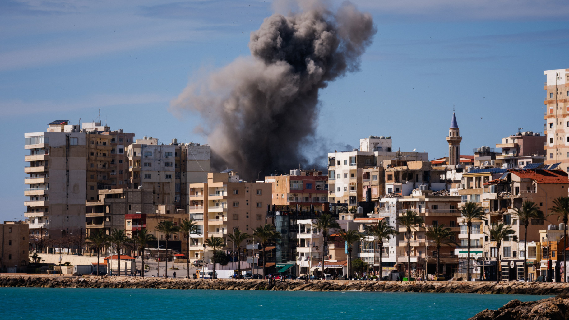 A plume of smoke and a fragment of concrete rise from the site of an Israeli airstrike on the eastern outskirts of Sour, in southern Lebanon, on 24 March 2026 (AFP)