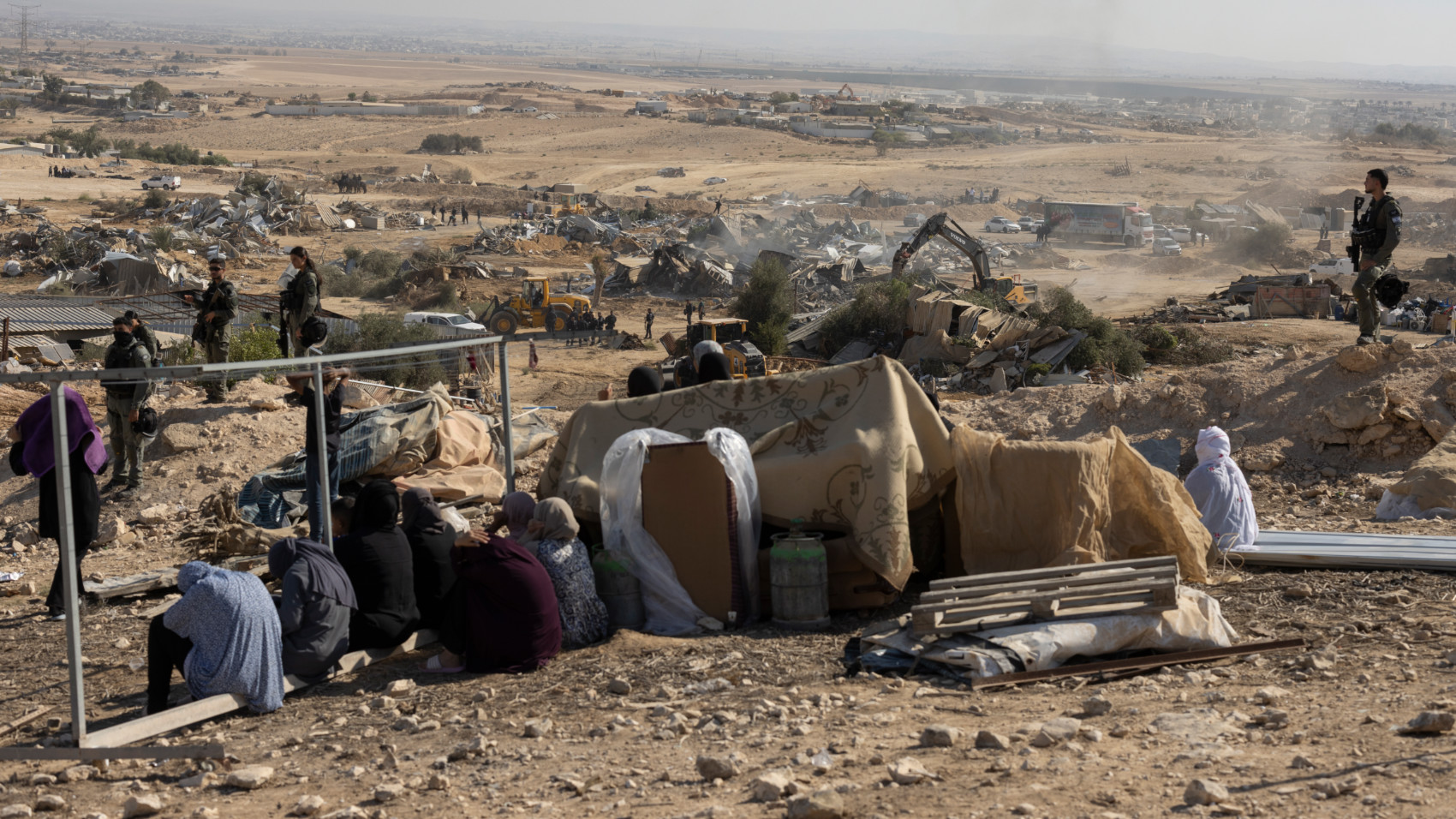 Bedouin families watch as Israeli police demolish their village of al-Sir in the Negev desert on 17 September 2025 (Oren Zif/MEE)