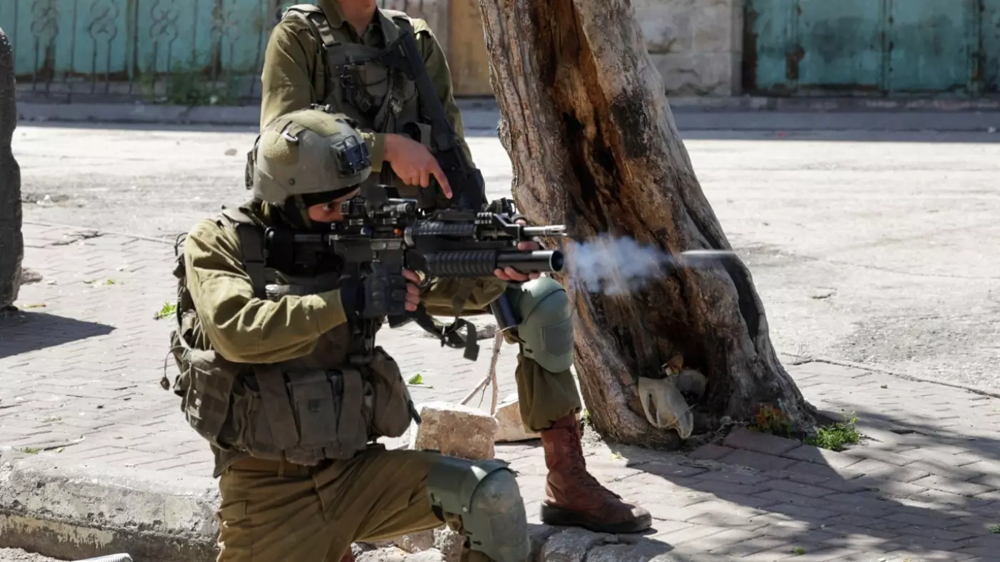 Israeli soldiers fire rubber bullets towards Palestinian protesters following the death announcement of a Palestinian hunger striker in Israeli detention on 2 May 2023, in Hebron, in the occupied West Bank (Hazem Bader/AFP)