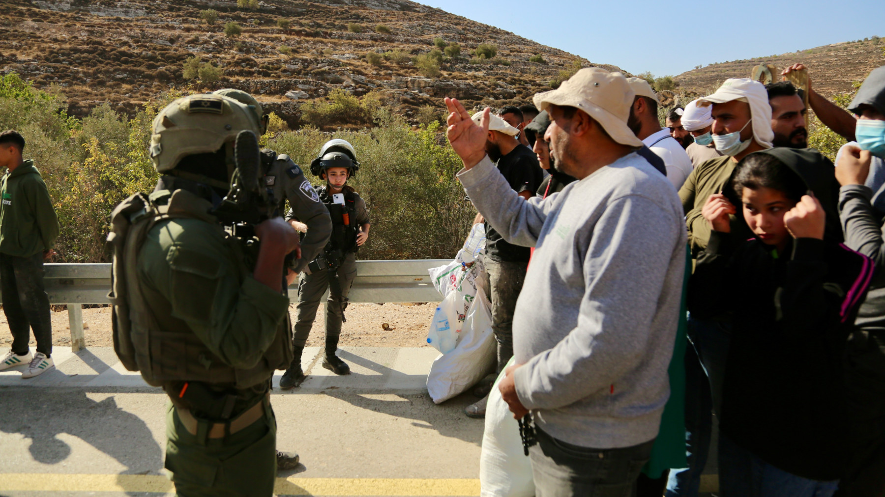 Israeli soldiers force Palestinians off their land as they harvested olives in Sair, near Hebron in the occupied West Bank, 23 October 2025 (Mosab Shawir/MEE)