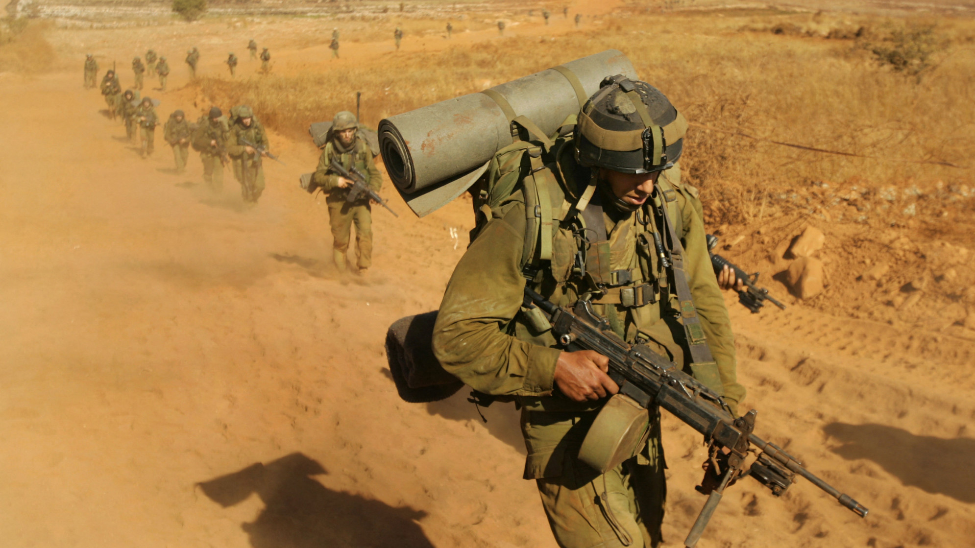 Israeli soldiers walk towards the Israel-Lebanon border back into northern Israel, 15 August 2006 (AFP)