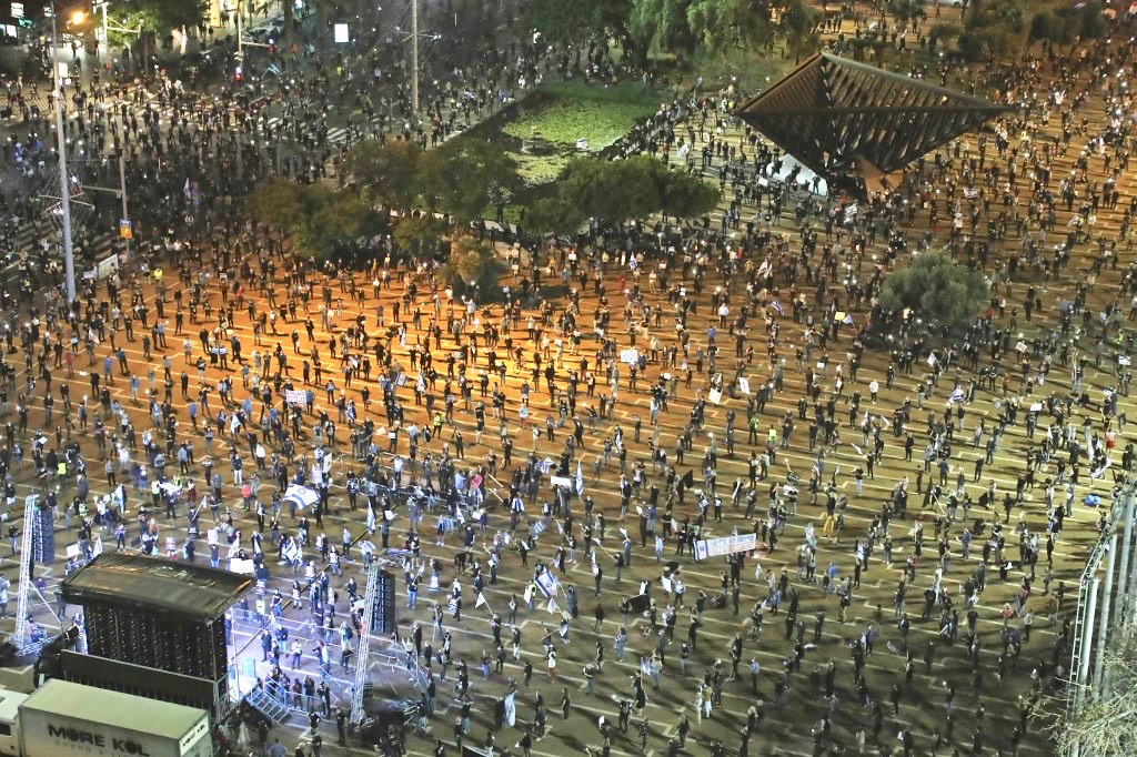 Israelis, keeping safe distance from one another, take part in 'Black Flag' demonstration on Sunday in Tel Aviv (AFP)
