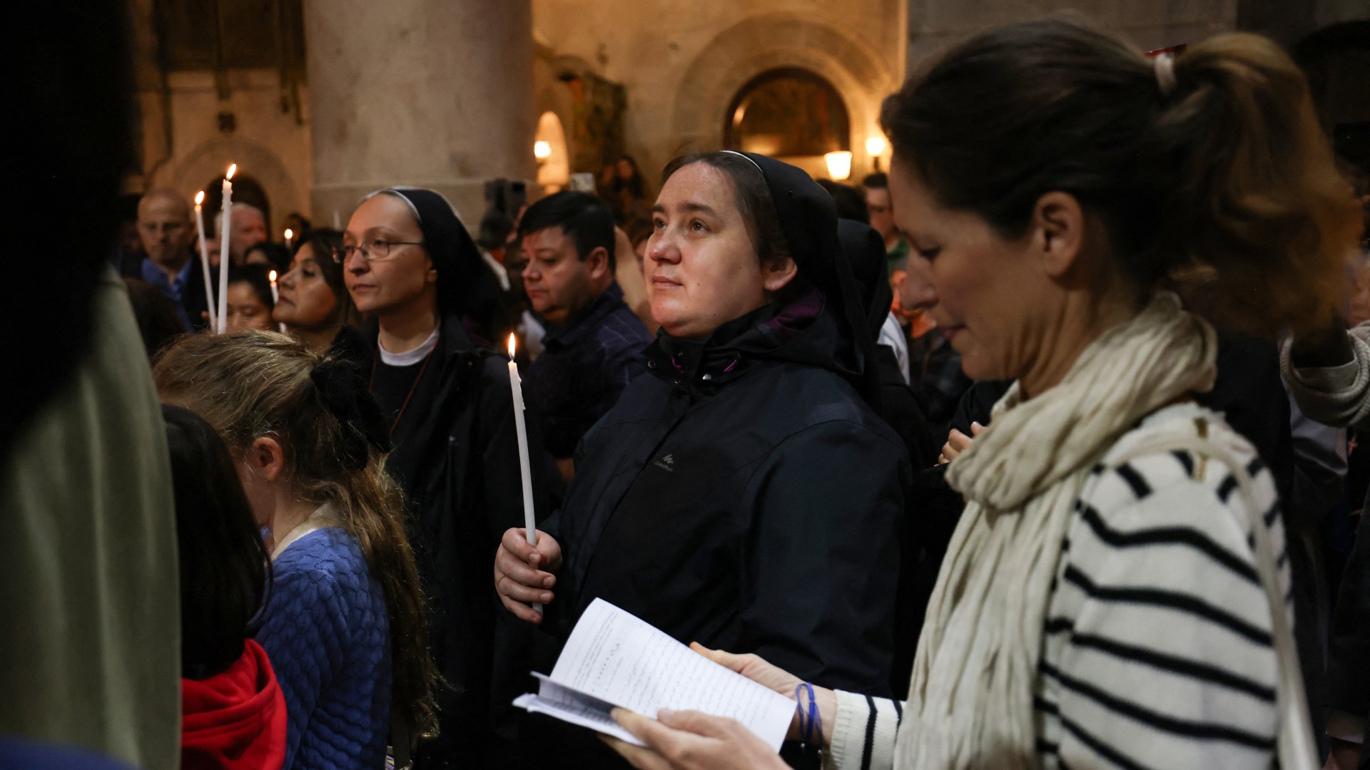 Christian worshippers pray at the Church of the Holy Sepulchre in the Old City of Jerusalem, during the Easter Sunday mass on 31 March (AFP)