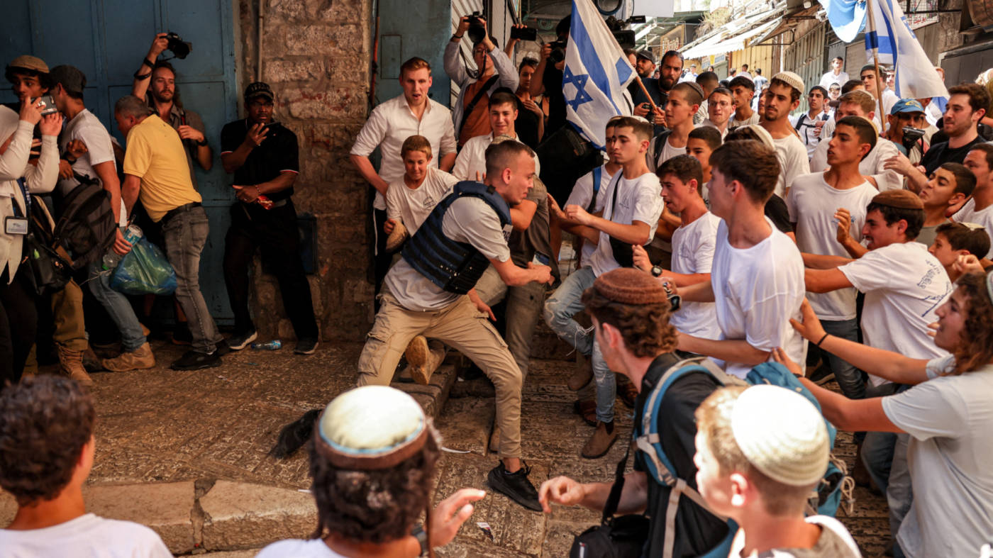 Israeli right-wing activists fight with Palestinian freelance journalists during the March of the Flags on 5 June 2024 in Jerusalem (AFP)