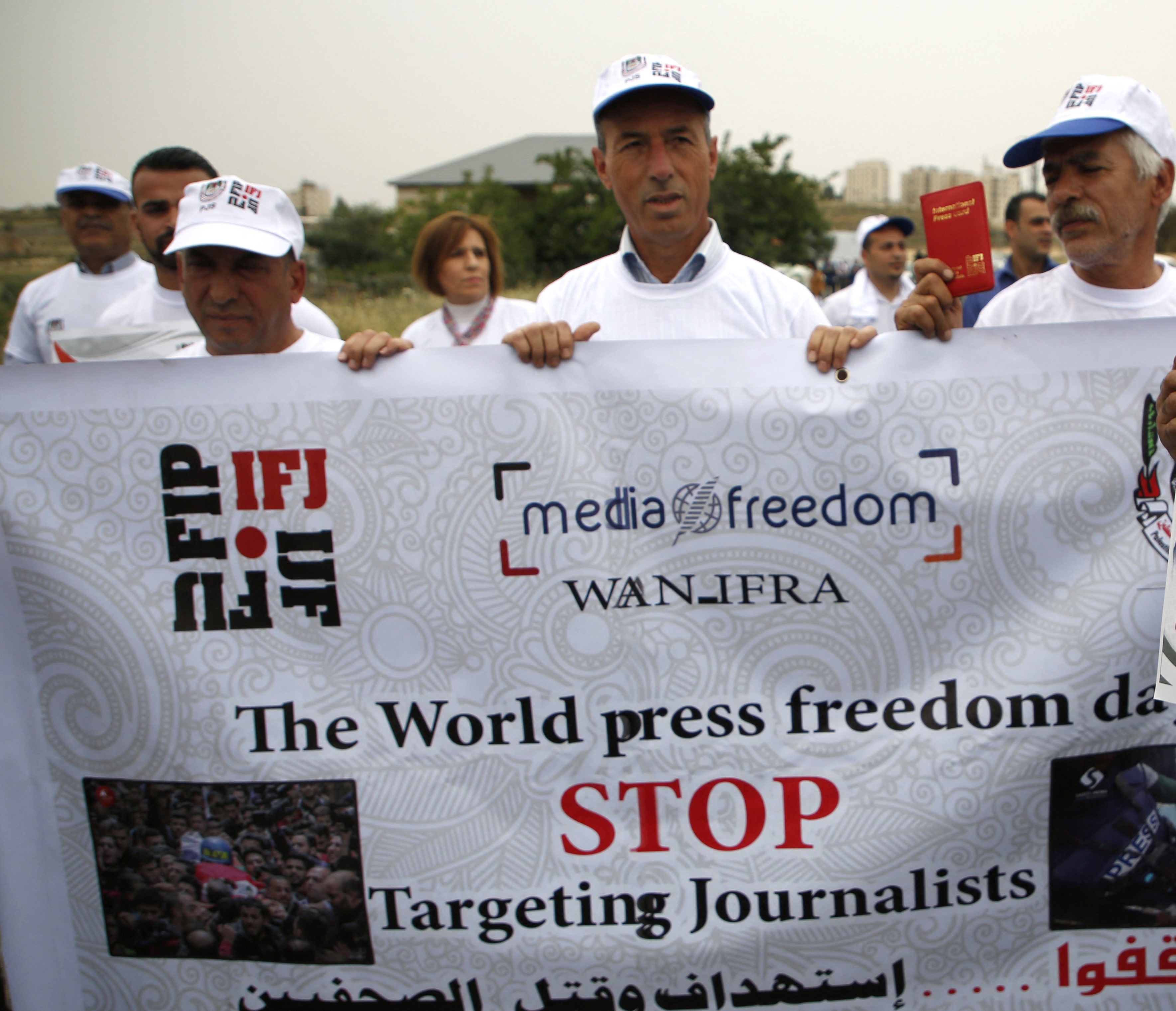 Palestinian journalists during a protest in front of the Beit El Israeli army checkpoint, near the West Bank city of Ramallah, on 6 May, 2018 (AFP)