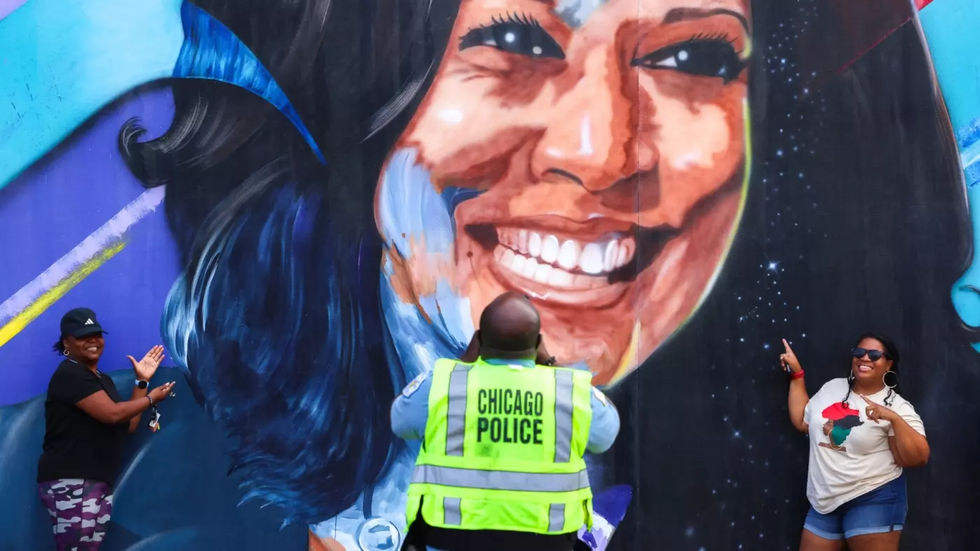 Police officer takes a photo in front of mural of Democratic presidential nominee US Vice President Kamala Harris outside United Center ahead of Democratic National Convention in Chicago, Illinois, 17 on August 2024 (Charly Triballeu/AFP)
