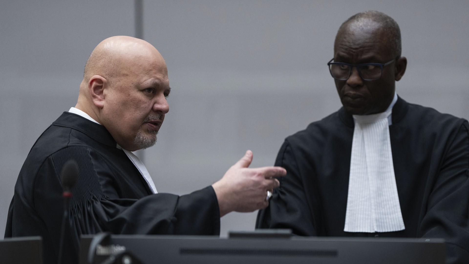 Chief Prosecutor Karim Khan (L) talks with Deputy Prosecutor Mame Mandiaye Niang in the courtroom as they wait for former Philippine President Rodrigo Duterte to appear via video link before the International Criminal Court (ICC) on charge of crimes against humanity over his deadly crackdown on narcotics, in The Hague on March 14, 2025.