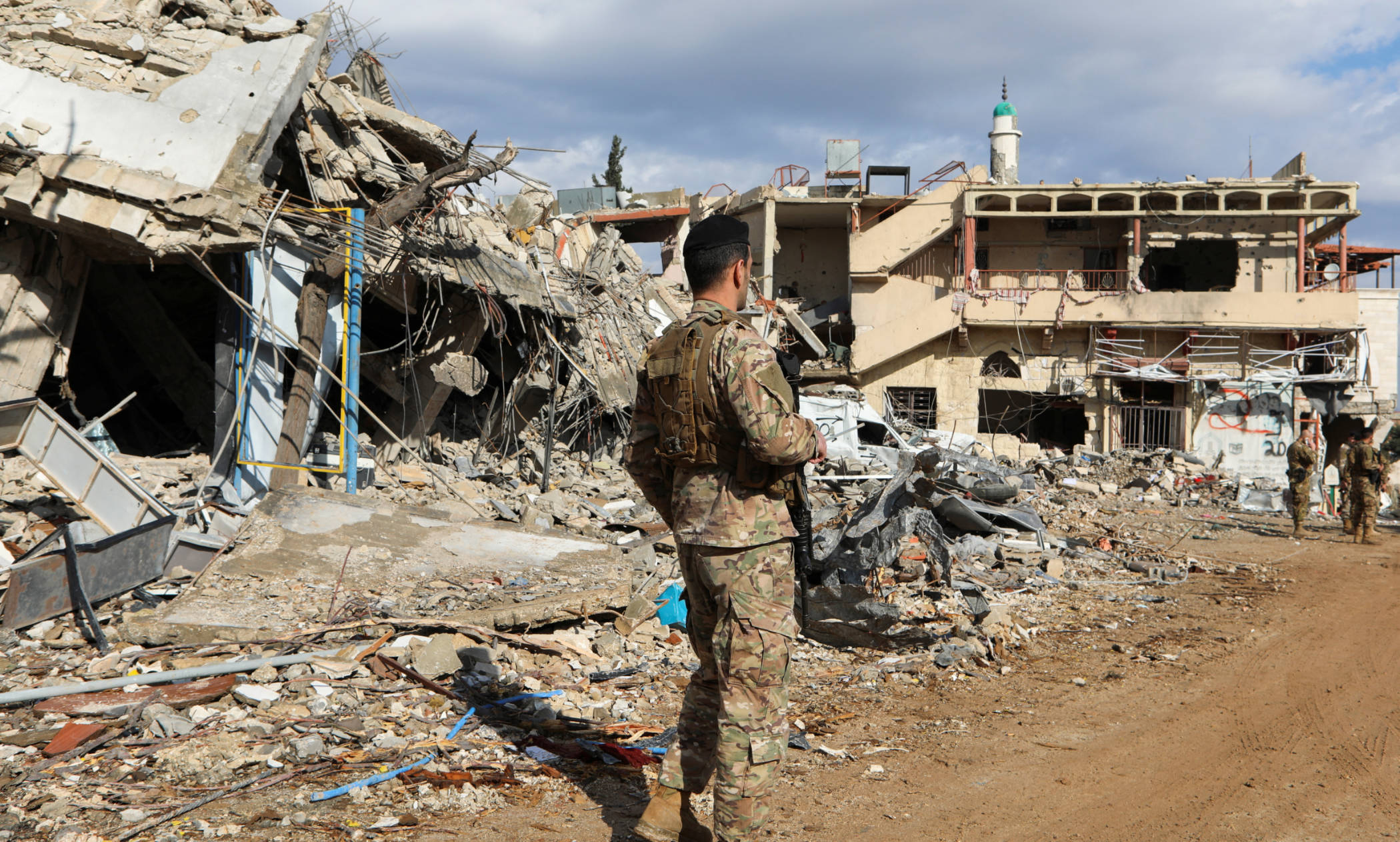 A Lebanese army member stands near rubble at a damaged site in the Lebanese village of Khiam, 23 December 2024 (Karamallah Daher/Reuters)