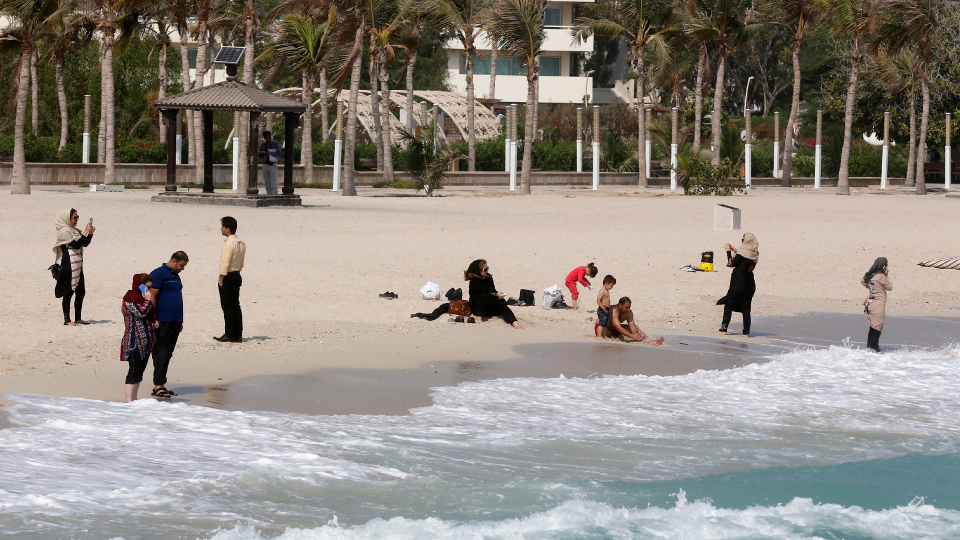 Iranian tourists sit on the beach in Iran's southern resort island of Kish on November 1, 2016 (AFP/Atta Kenare)
