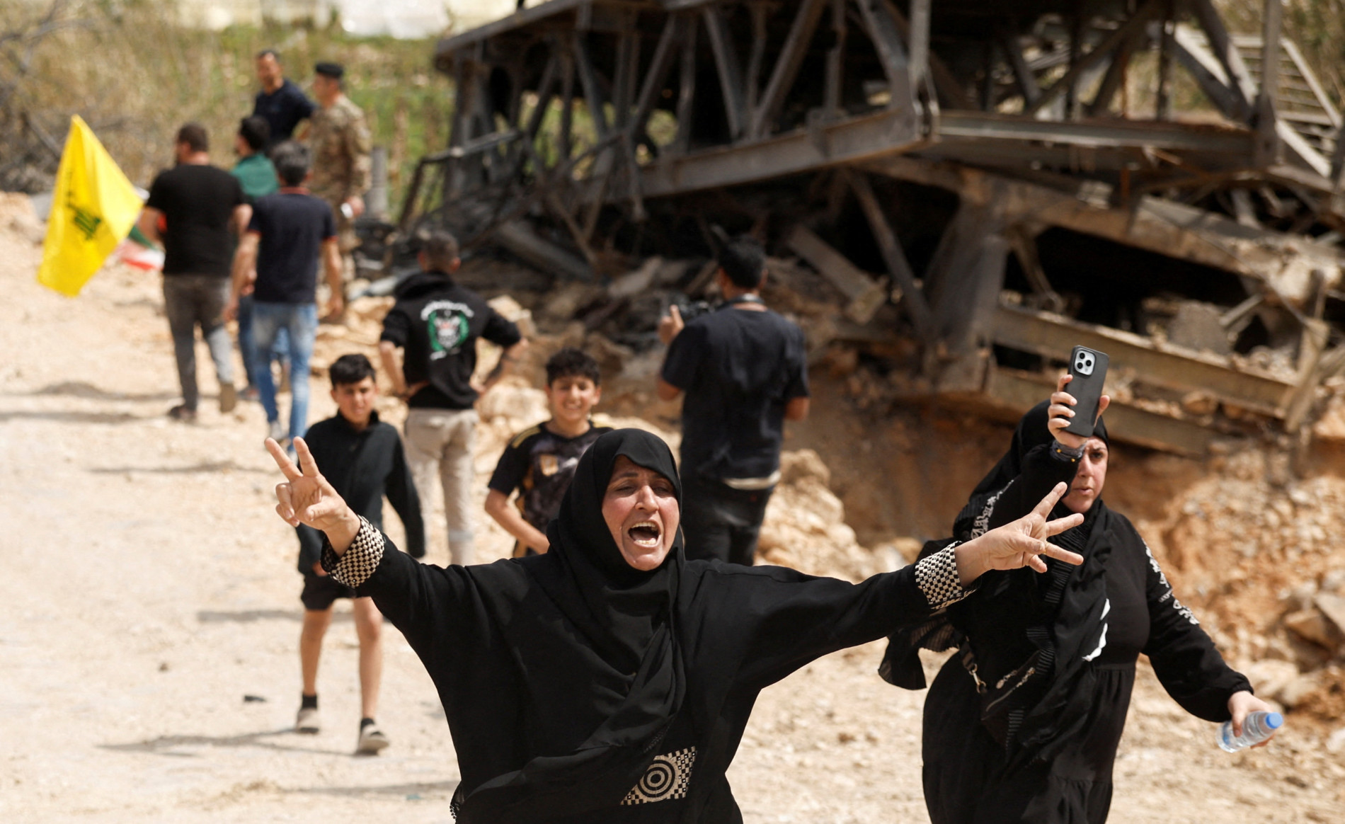 Women react as displaced people make their way back home near the destroyed Qasmiyeh bridge linking southern Lebanon to the rest of the country, 17 April 2026 (Reuters)