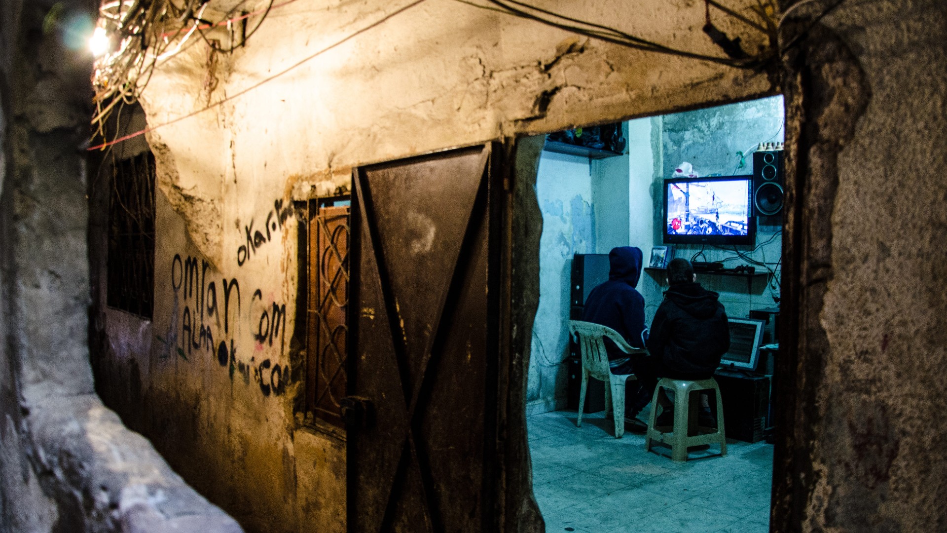 Two boys play video game in Shatila camp in Beirut on 6 March 2016 (Susanna D'Aliesio/SOPA via ZUMA Wire/Reuters)