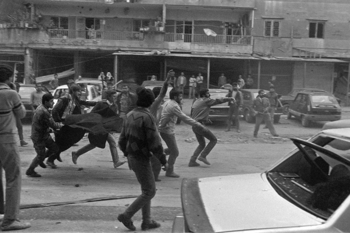Rescuers carry the body of a victim in a southern suburb of Beirut in March 1985, 15 minutes after a car, packed with TNT exploded in a crowded street (AFP)