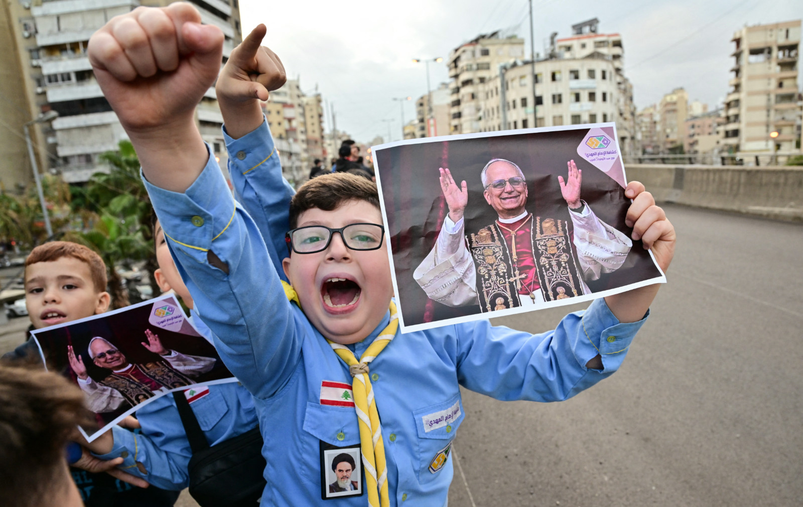 Imam Al-Mahdi scouts hold portraits of Pope Leo as they wait for his arrival in Beirut's southern suburbs, 30 November 2025 (AFP)