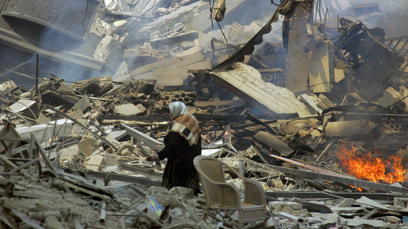 A Lebanese woman walks amid rubble of destroyed residential buildings in a southern Beirut neighbourhood following Israeli air strikes on 24 July 2006 (AFP)