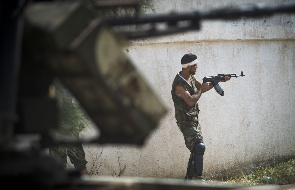 A fighter loyal to the GNA fires during clashes with forces loyal to Khalifa Haftar south of the Tripoli suburb of Ain Zara on 25 April (AFP)