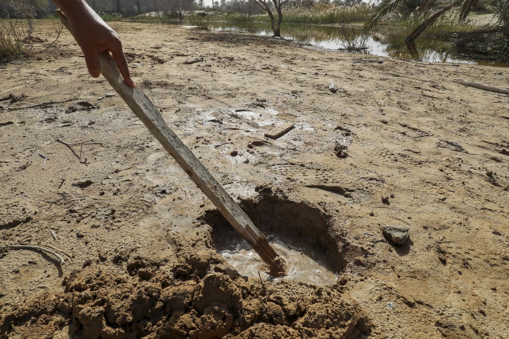 L’eau s’infiltre par un trou dans le sol de la ville de Zliten en raison de la montée des eaux souterraines, le 13 février (Mahmoud Turkia/AFP)