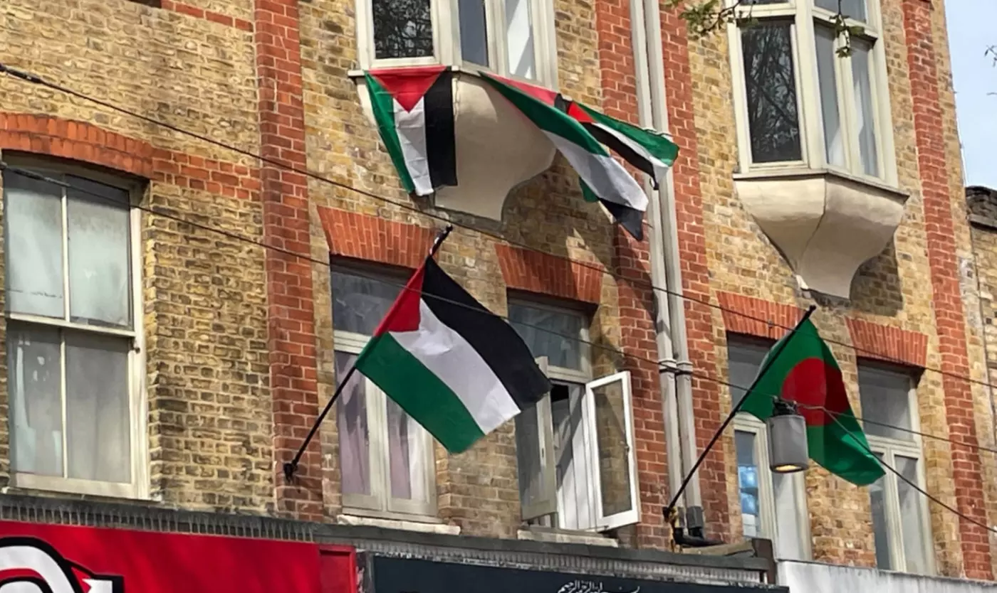 A trio of Palestinian flags fly next to a Bangladeshi flag from private premises in Tower Hamlets, east London (MEE/Simon Hooper)