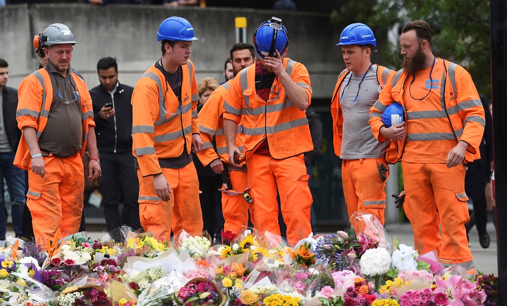 Des ouvriers du bâtiment déposent des fleurs près du lieu de l’attentat du London Bridge, en juin&nbsp;2017 (Reuters)