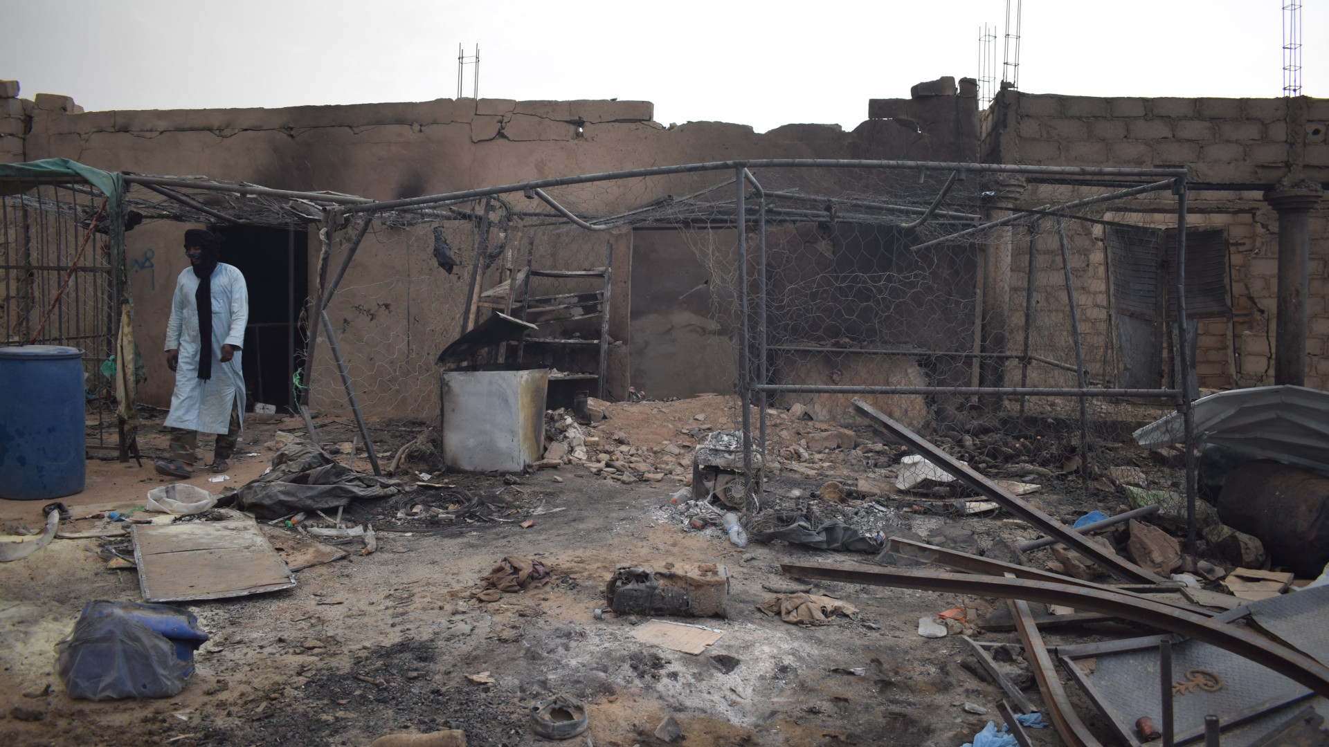 A man walks past a structure damaged in a drone attack allegedly carried out by the Malian army near the Algerian border in Talhandak on 8 July 2026 (AFP)