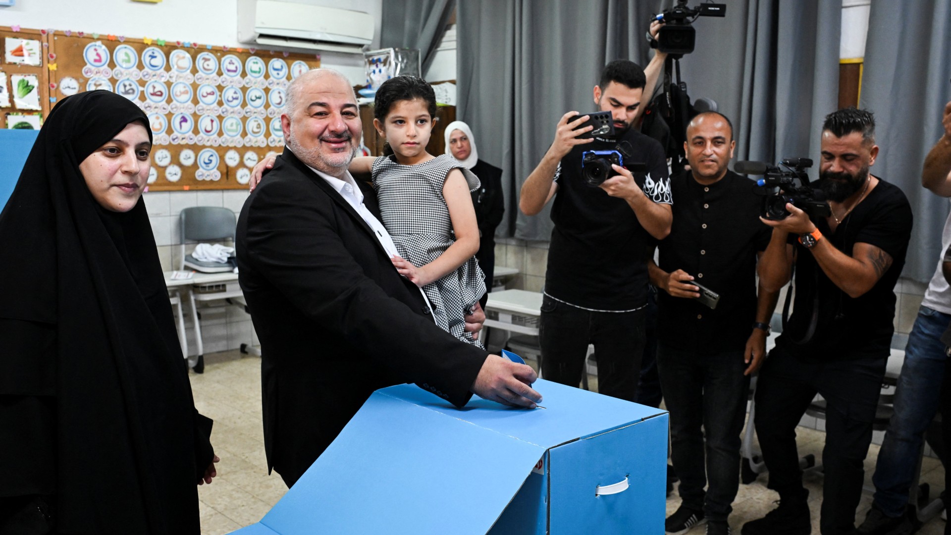 Palestinian candidate Mansour Abbas, leader of the Raam party, holds his daughter as he places his vote at a polling station in Maghar, Israel, 27 October 2026 (Reuters/Rami Shlush)