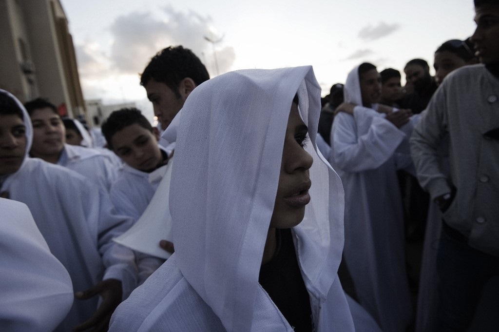 Libyan youths dressed as 'martyrs of the revolution' participate in a parade on the one year anniversary of the start of protests against Gaddafi (AFP)