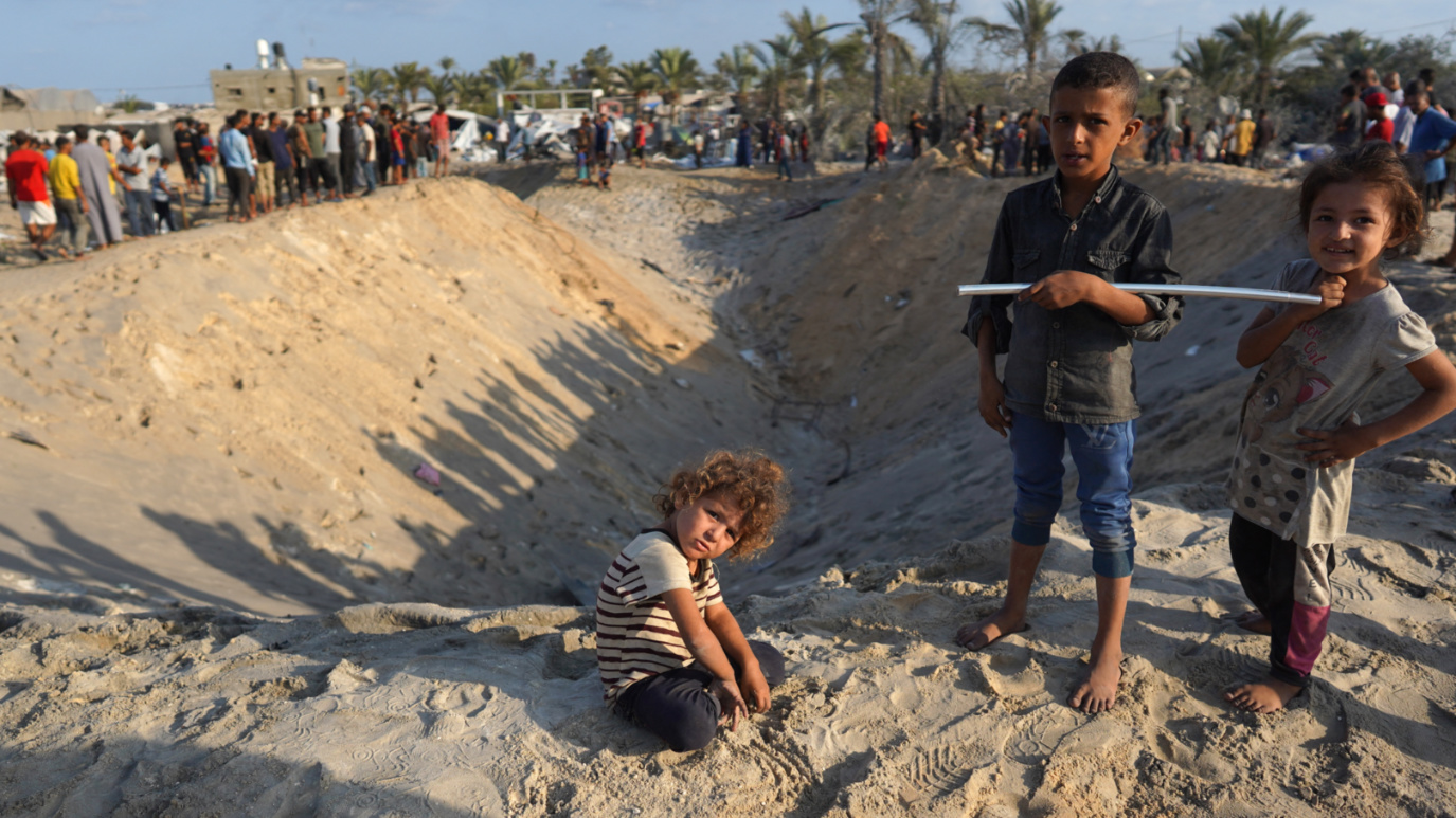Palestinian children inspect the damages near the site of Israeli strikes on al-Mawasi, southern Gaza on 10 September 2024 (Bashar Taleb/AFP)