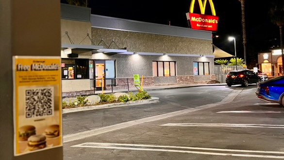 A fake promotional sticker is placed near a McDonalds. When the QR code is scanned, it redirects to a page with information on Israel's war on Gaza.