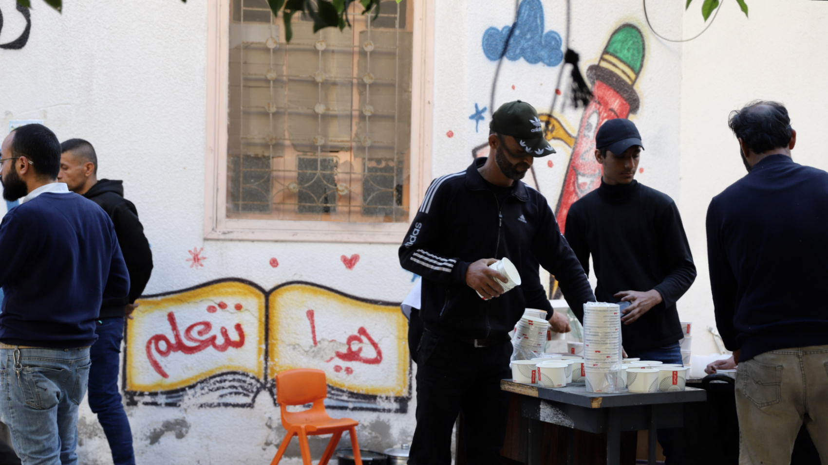 Men distribute food to people in Gaza City (Mohammed al-Hajjar/MEE)