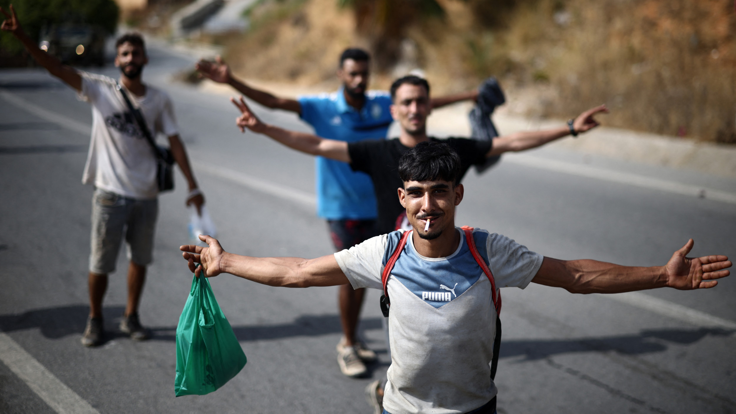 Young men pose for a picture while being escorted to the Ceuta-Morocco border in the Spanish North African enclave of Ceuta on 1 August 2026 (AFP)