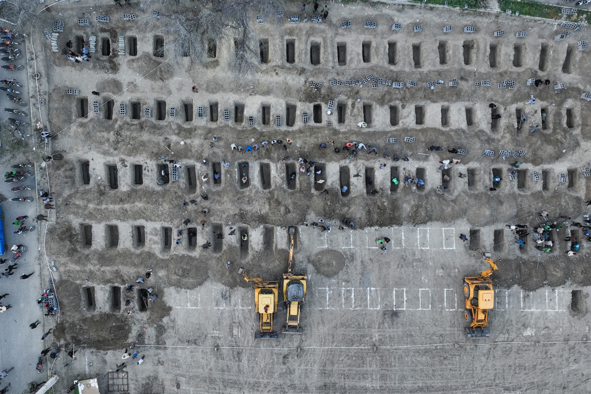Aerial picture showing mourners digging graves during the funeral for children killed in a strike on a primary school in Minab, Iran (AFP/Iranian Press Centre)