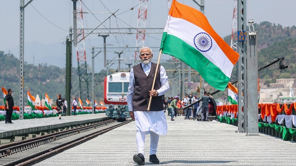 This photograph taken and released by the Indian Press Information Bureau (PIB) on June 6, 2025 shows India's Prime Minister Narendra Modi holding national flag during the inauguration of the Chenab Rail Bridge as a part of the Kashmir rail link, in Reasi, in Jammu and Kashmir. Modi arrived in Kashmir on June 6, his first visit to the contested Himalayan region since a conflict with arch-rival Pakistan last month, and opened a strategic railway line. Indian Press Information Bureau (PIB) / AFP