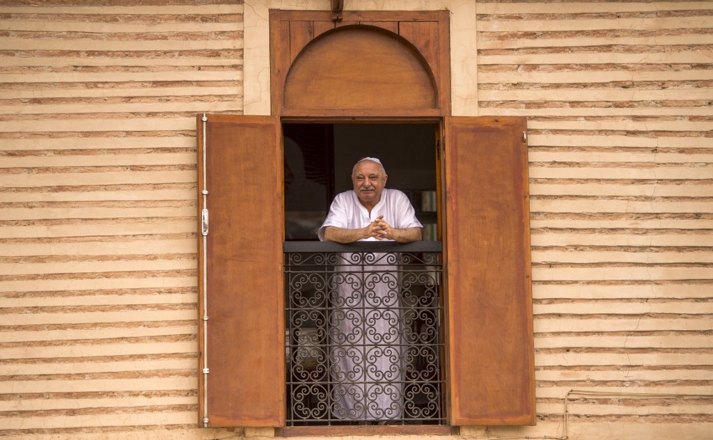A Moroccan Jewish man looks out his window at the street below from his house in the 