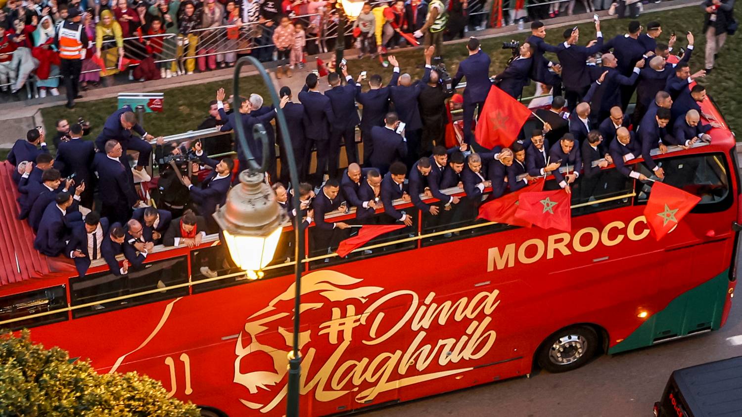 Supporters cheer as Morocco's national football team arrives to the centre of the capital Rabat, on 20 December 2022, after the Qatar 2022 World Cup.