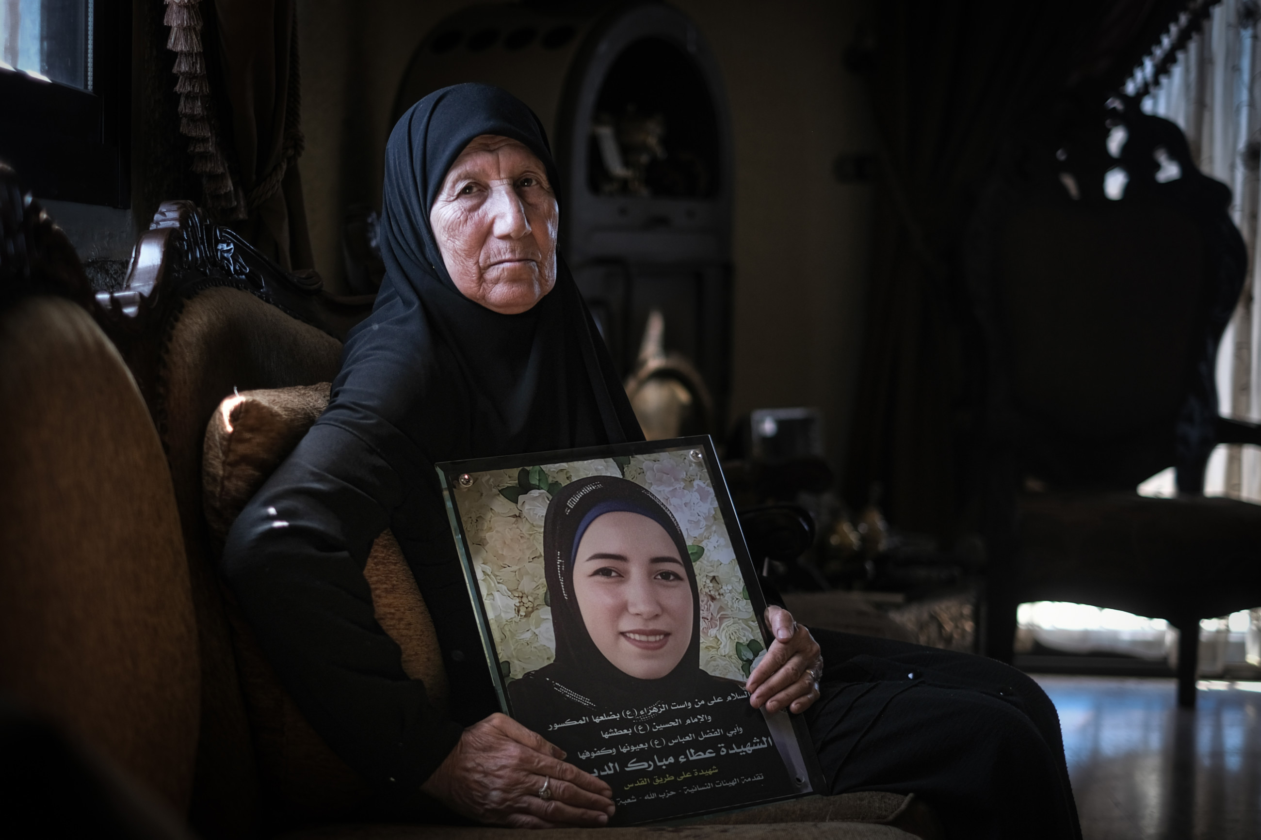 The mother of Ataa Mubarak, 28-year-old nurse killed in the pagers attack, holds her daughter's framed portrait (João Sousa/MEE)