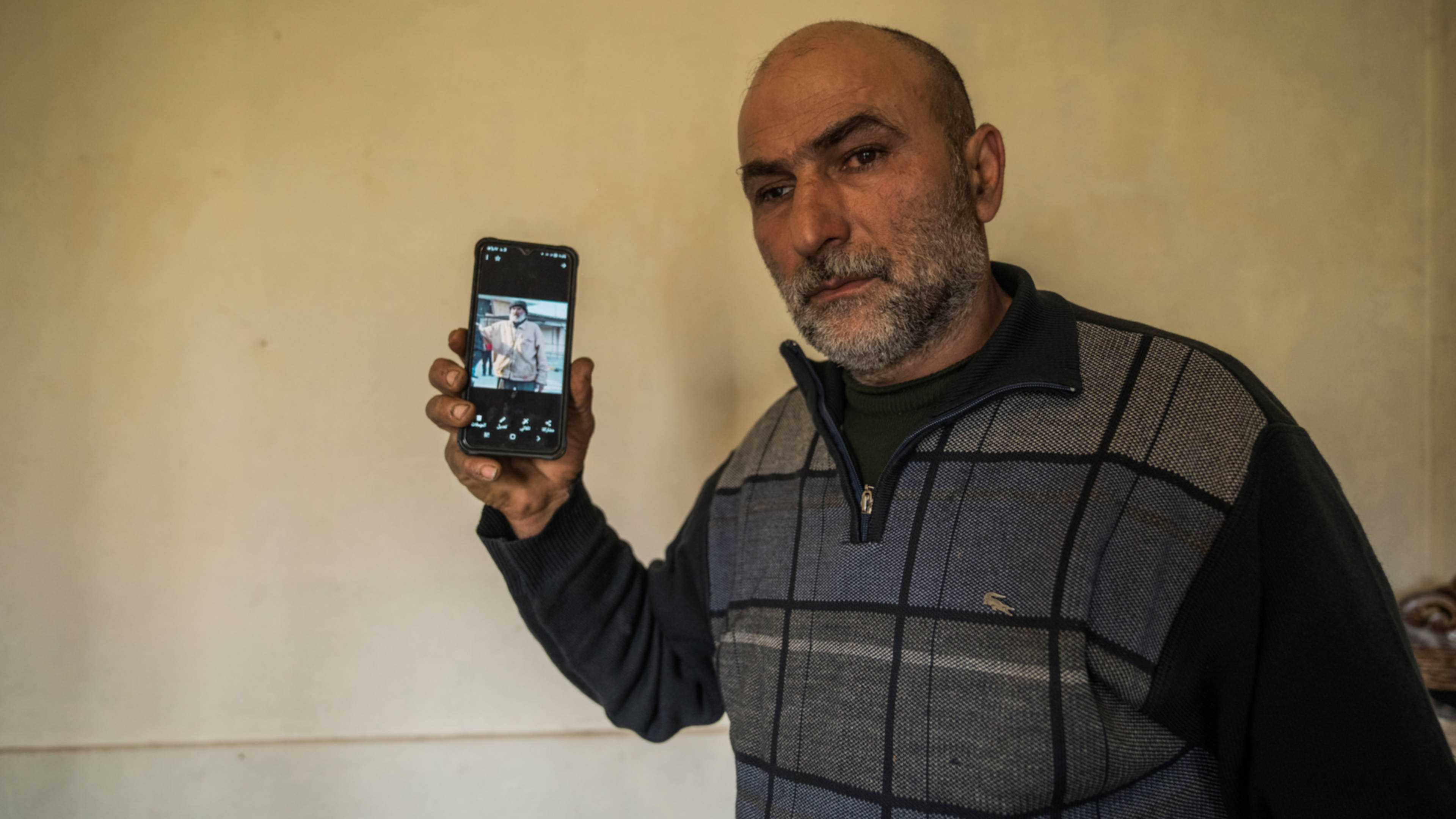 Muammar Ali holds a photo of the man he believes is his kidnapped brother Ali (Raged Waked/MEE)