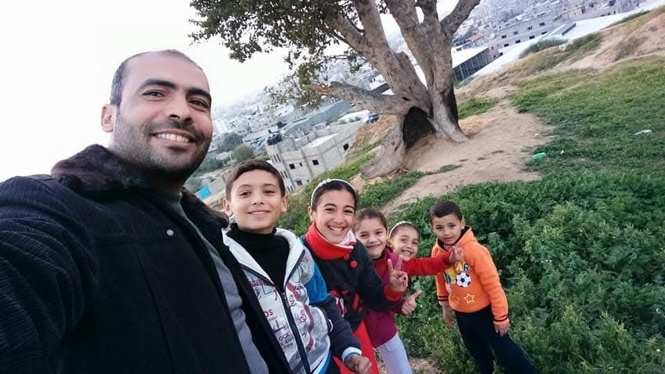 An undated photo of the author’s uncle, Yasser Radwan, with his children, taken before they were killed in an Israeli air strike during the war on Gaza.