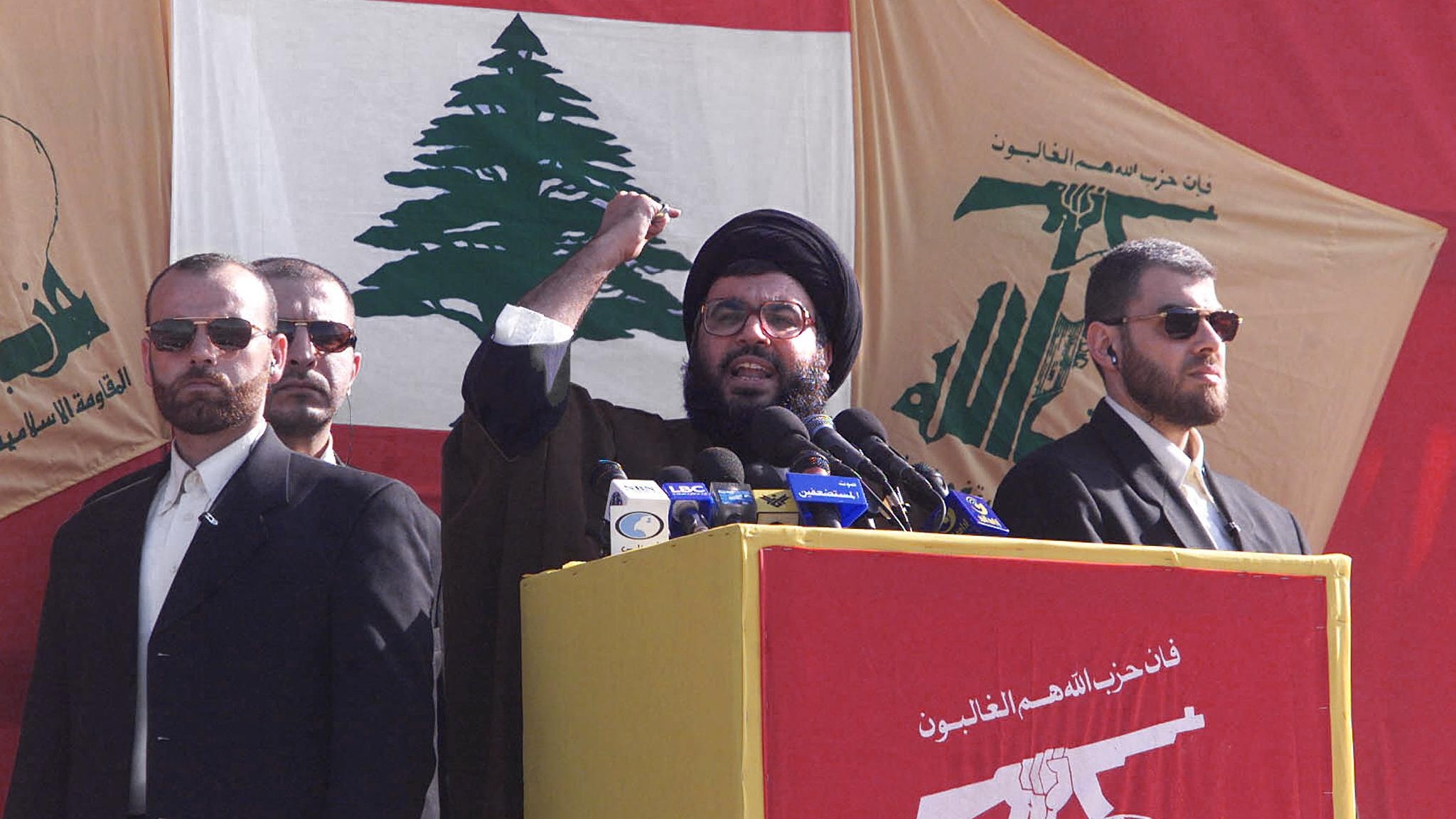 Hassan Nasrallah gives a speech, flanked by bodyguards, during a victory rally in Lebanon's Bint Jbeil on 26 May 2000 (Rabih Moghrabi/AFP)