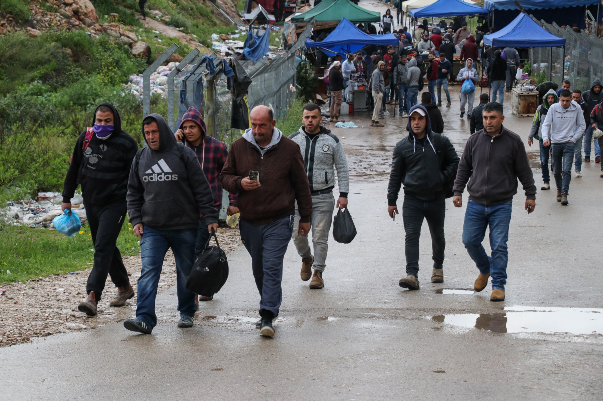 Des travailleurs palestiniens se rendent au check-point de Nilin le 18&nbsp;mars, alors qu’Israël leur a exceptionnellement permis de passer la nuit dans le pays (MEE/Mohammad Abu Zaid)