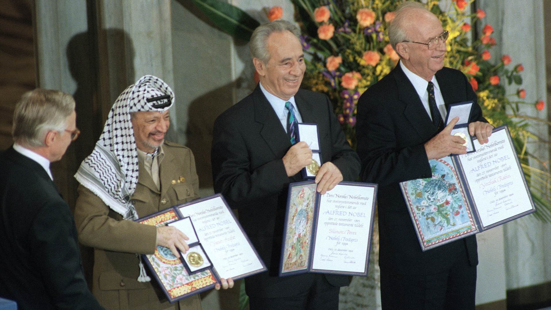 PLO leader Yasser Arafat (L-R), Israeli Foreign Minister Shimon Peres, and Israeli Prime Minister Yitzhak Rabin pose with their Nobel Peace Prize medals at Oslo City Hall on 10 December 1994 (AFP)