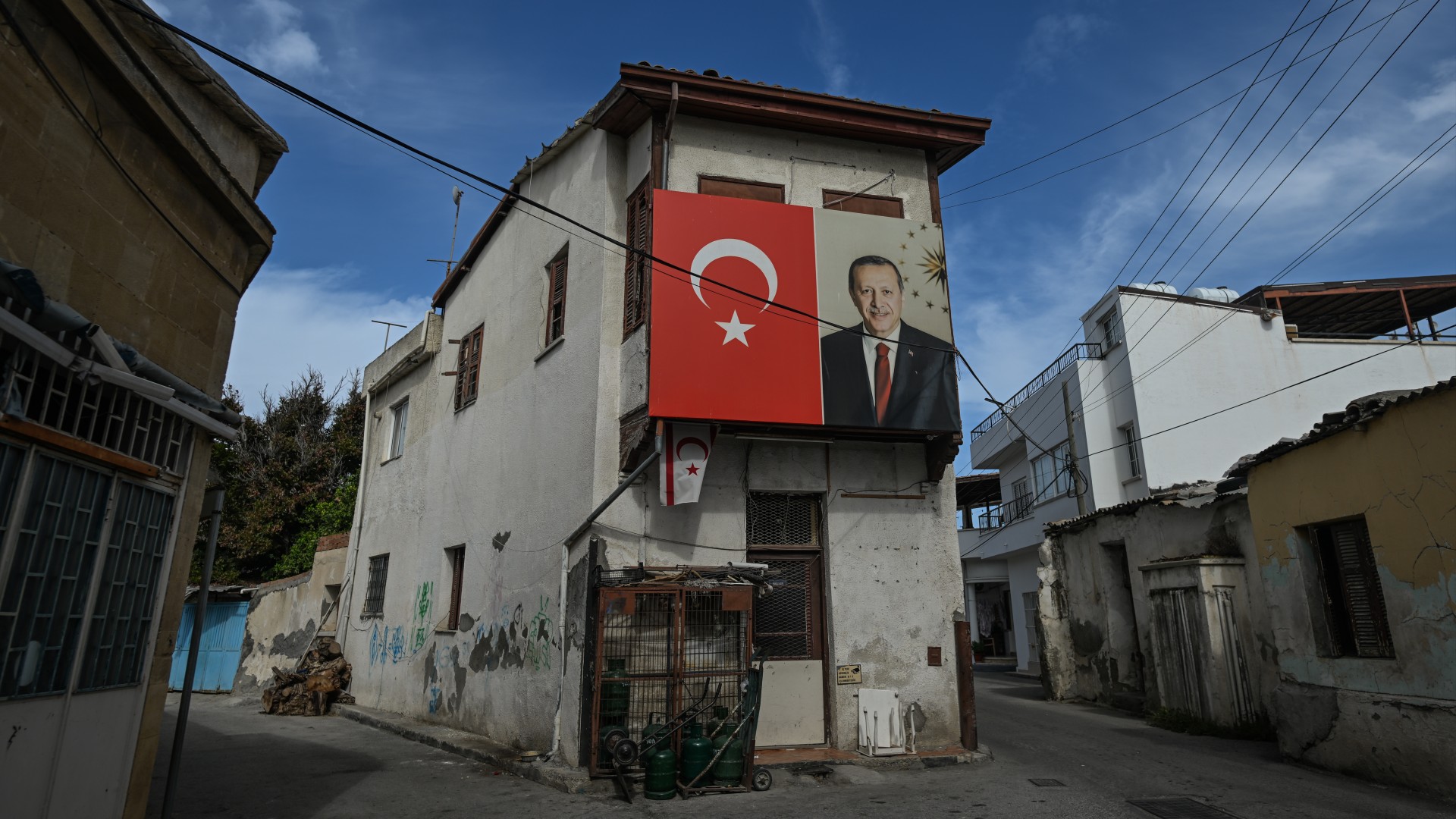Flags of Turkey and an image of Turkish President Recep Tayyip Erdogan are seen in the northern part of Nicosia, 21 October 2025 (STR/NurPhoto via Reuters)