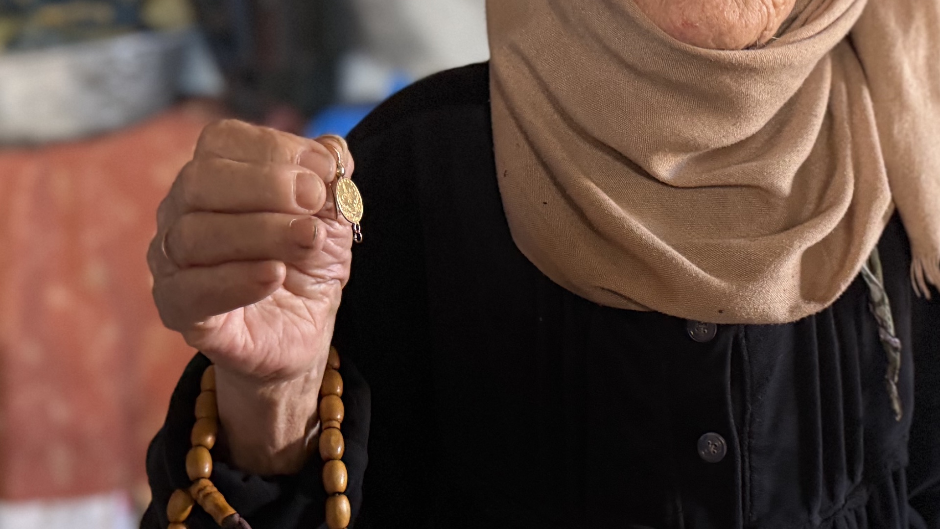 Fatema Obaid holds the earrings gifted to her by her father before the 1948 Nakba (Hani Abu Rezeq/MEE)