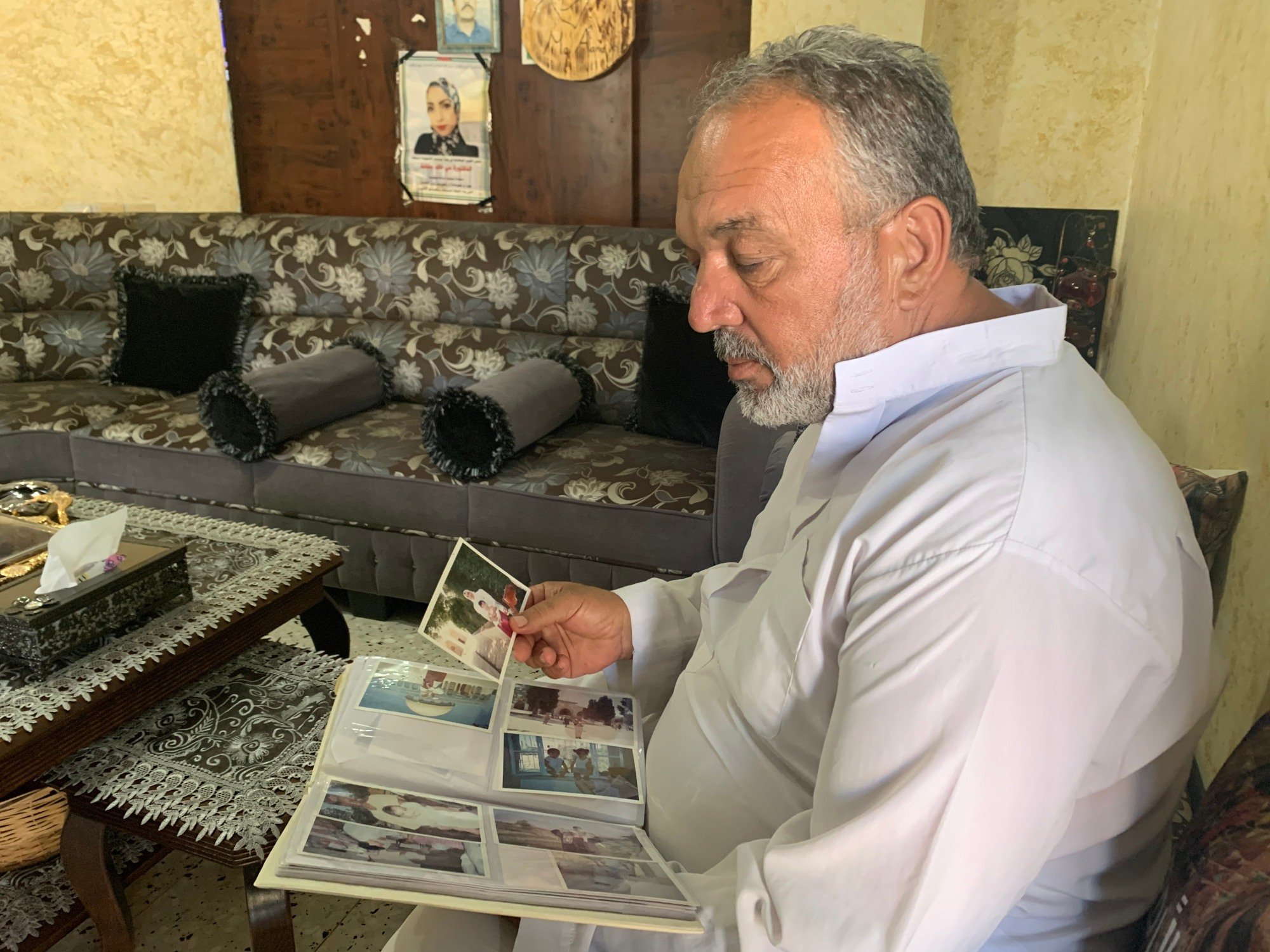 Khaled Afana regarde des photographies de sa fille Mai chez eux à Abu Dis, près de Jérusalem (MEE/Shatha Hammad)