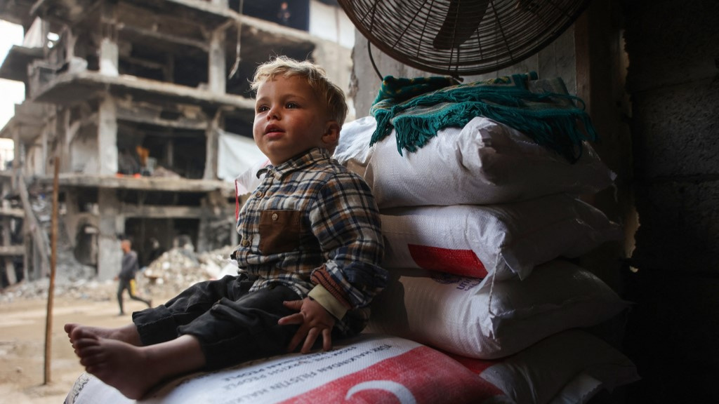 A Palestinian child sits in Beit Lahia, Gaza, on 9 March 2025 (Omar al-Qattaa/AFP)