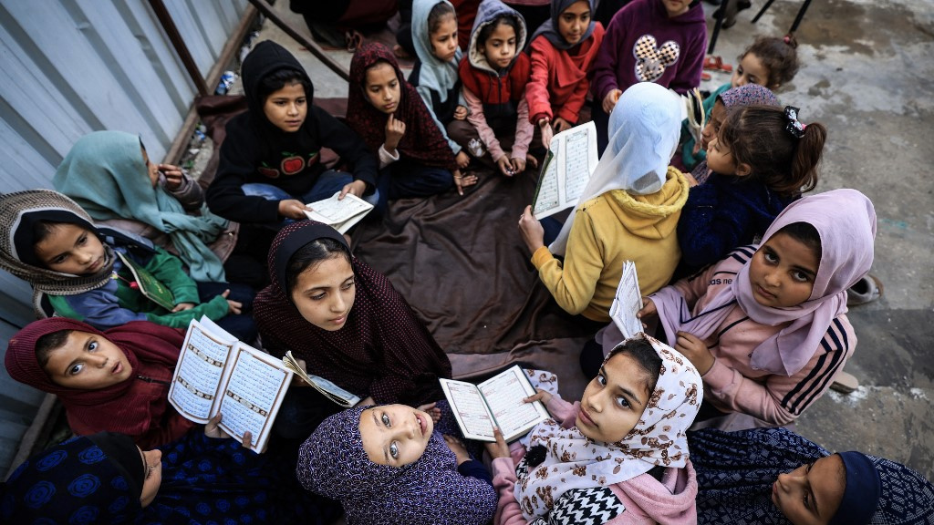Displaced Palestinian children attend a Quran class at Bear al-Saba school in Rafah, Gaza, on 24 January 2024 (AFP)