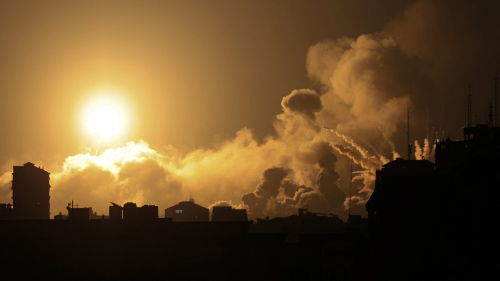 Smoke rises above buildings in Gaza City during an Israeli air strike on 8 October 2023 (AFP)