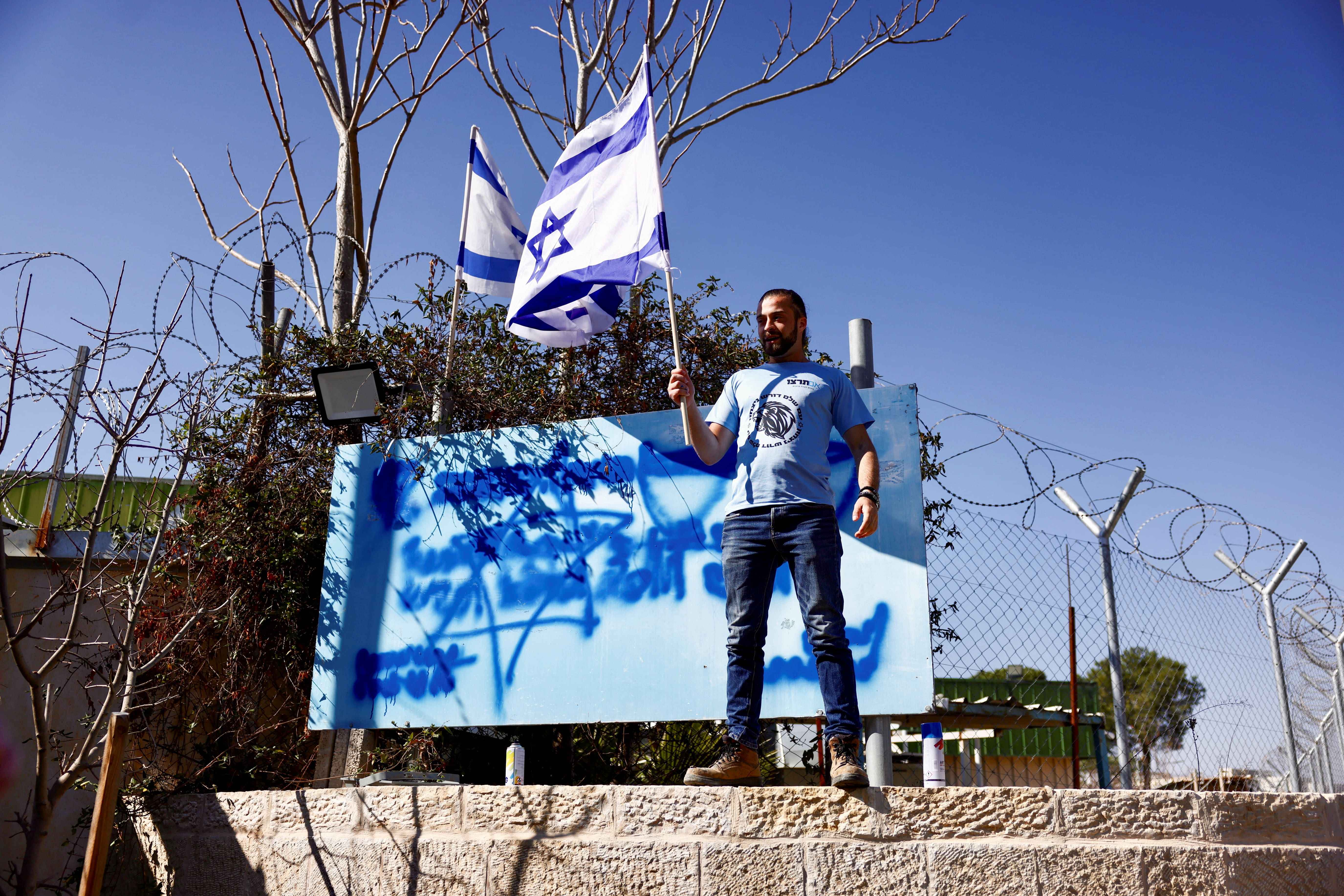 Far-right Israeli holds an Israeli flag at an event celebrating the ban on Unrwa outside the East Jerusalem headquarters of the agency on 30 January, 2025 (Reuters/Jamal Awad)