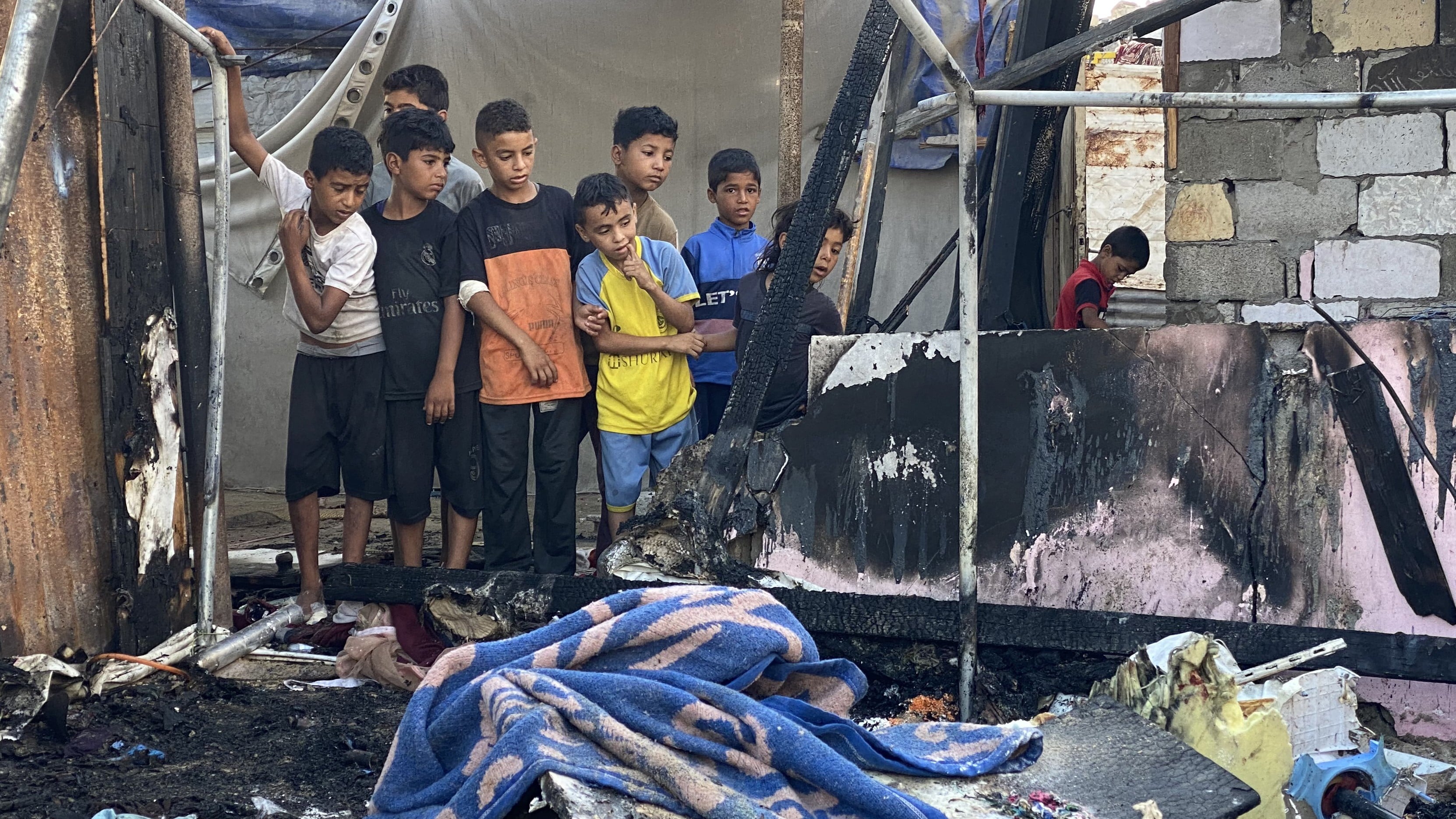 Palestinian children inspect the aftermath of an Israeli attack on the 'safe zone' of al-Mawasi in Khan Younis, south Gaza, on 7 August 2025 (AFP)