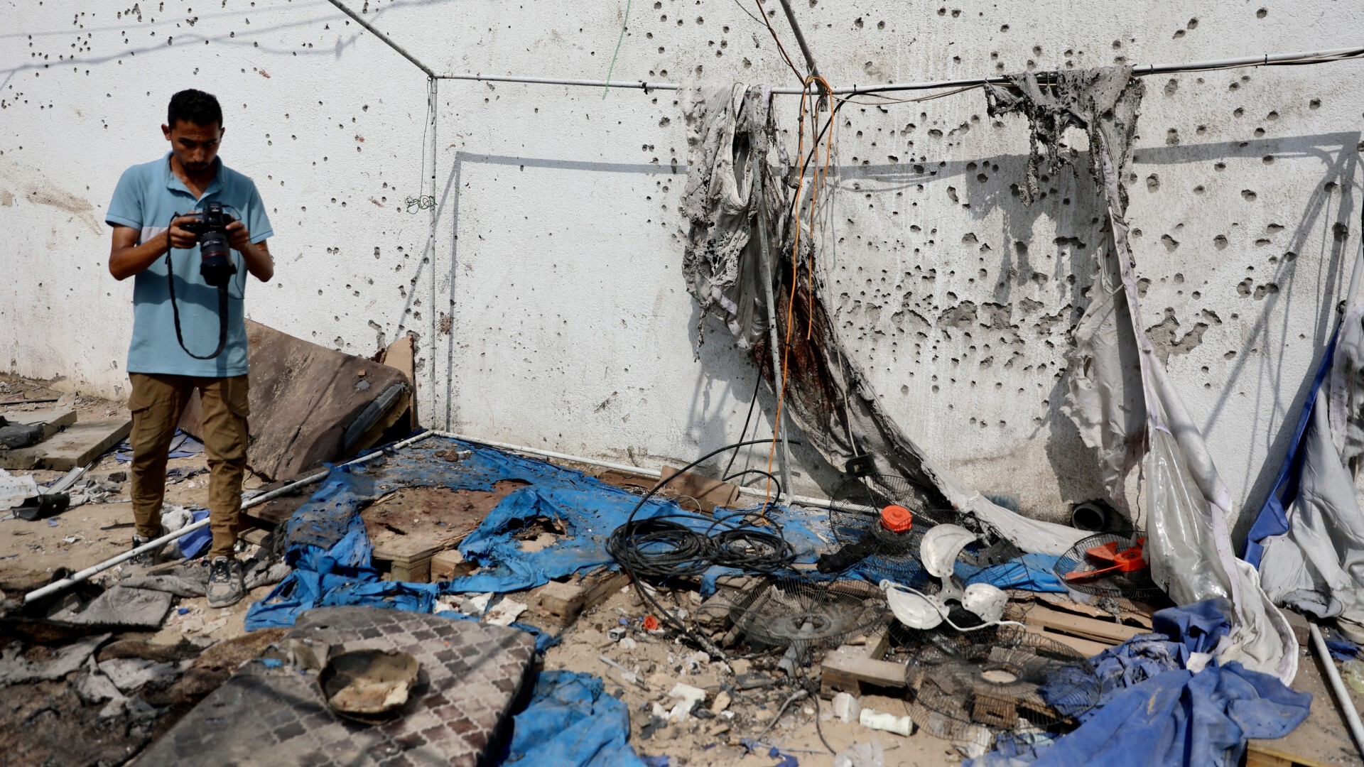 A photojournalist surveys the wreckage a day after Israeli forces targeted a media tent, killing six journalists near al-Shifa hospital in Gaza City (Mohammed al-Hajjar/MEE)
