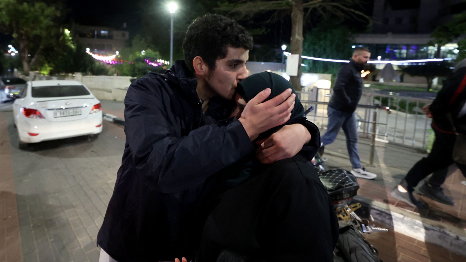 A newly released prisoner hugs a relative in Ramallah in the occupied West Bank early on 1 December 2023.