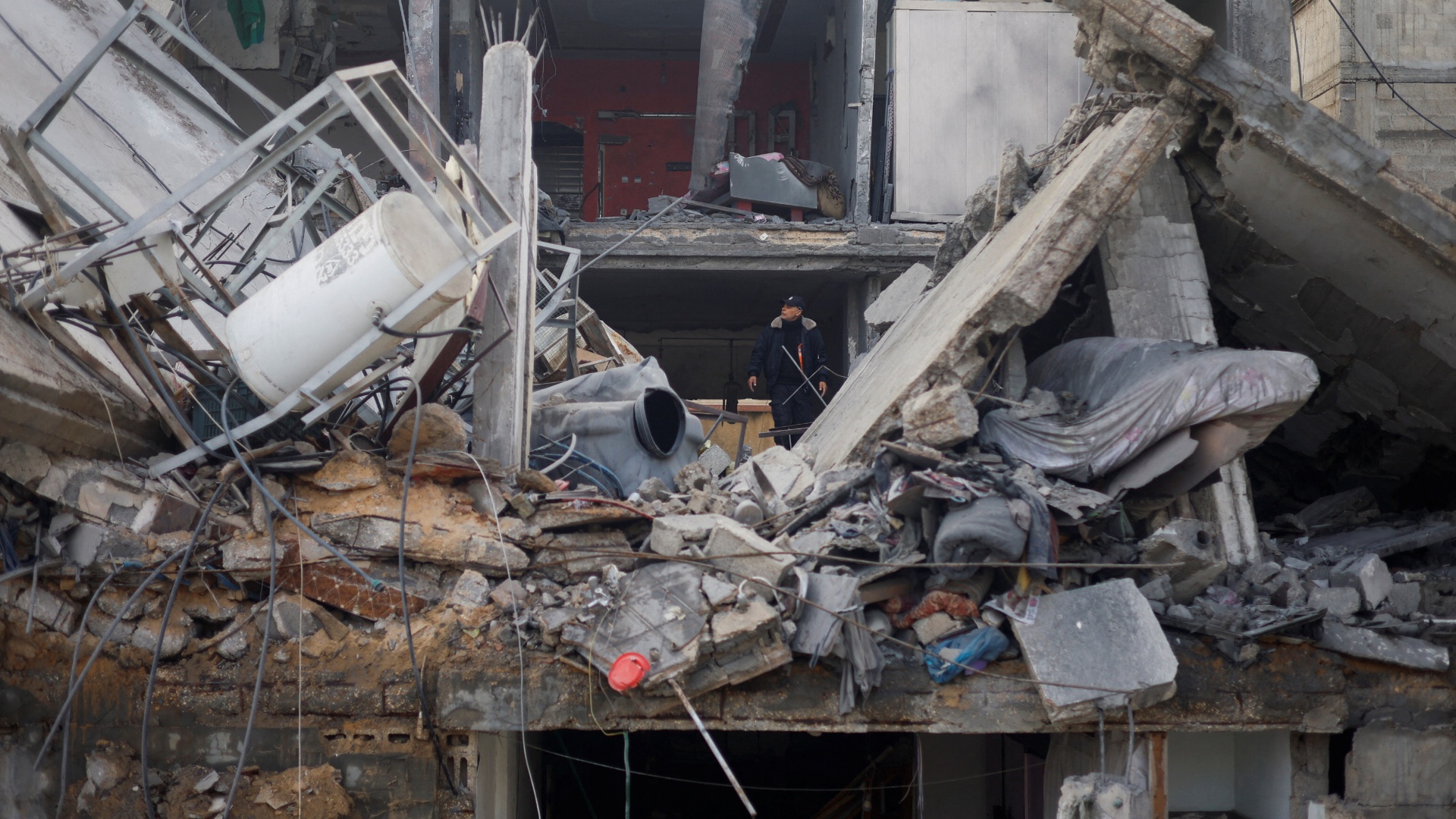 Palestinians inspect the site of an Israeli strike on a house in Rafah in the southern Gaza Strip 27 February 2024 (Reuters/Mohammed Salem)